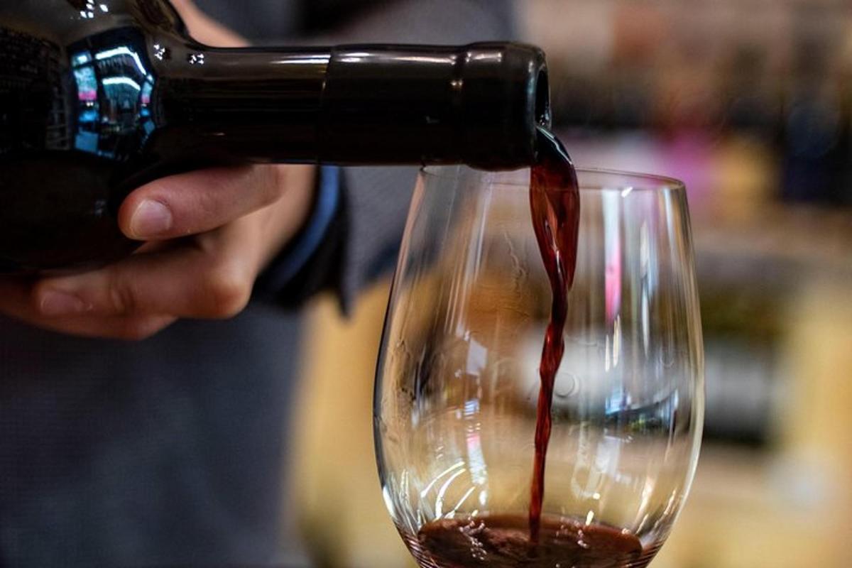 en person, der hælder vin i et vinglas
