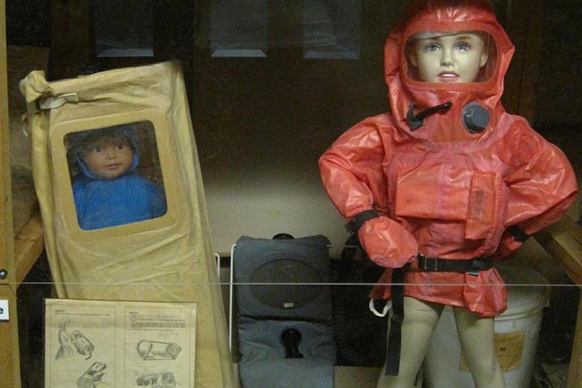 una bambola con un impermeabile rosso in piedi accanto a un bambino