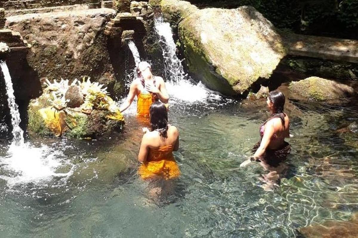 un gruppo di persone in acqua vicino a una cascata