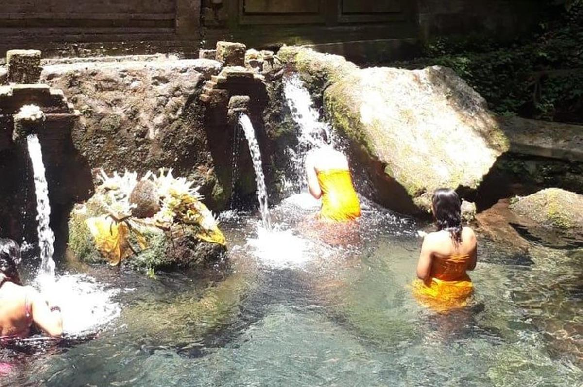un gruppo di persone in acqua davanti a una cascata