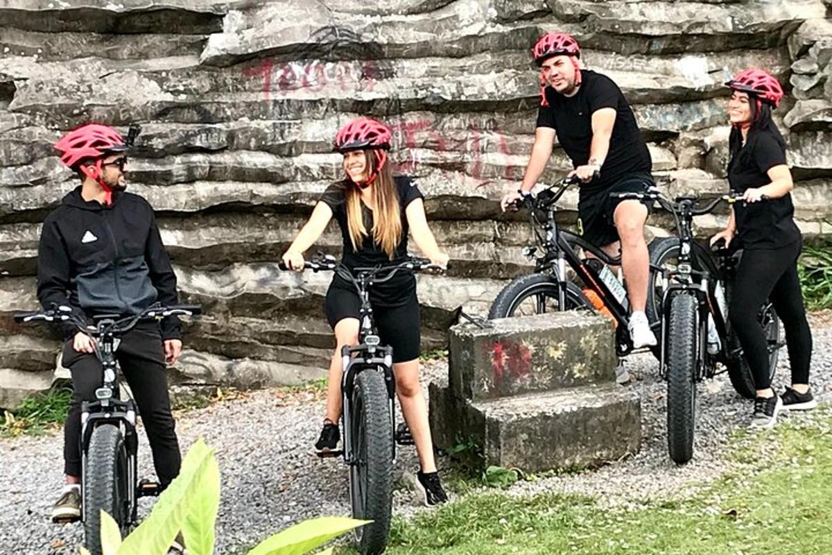 a group of people riding bikes in front of a stone wall