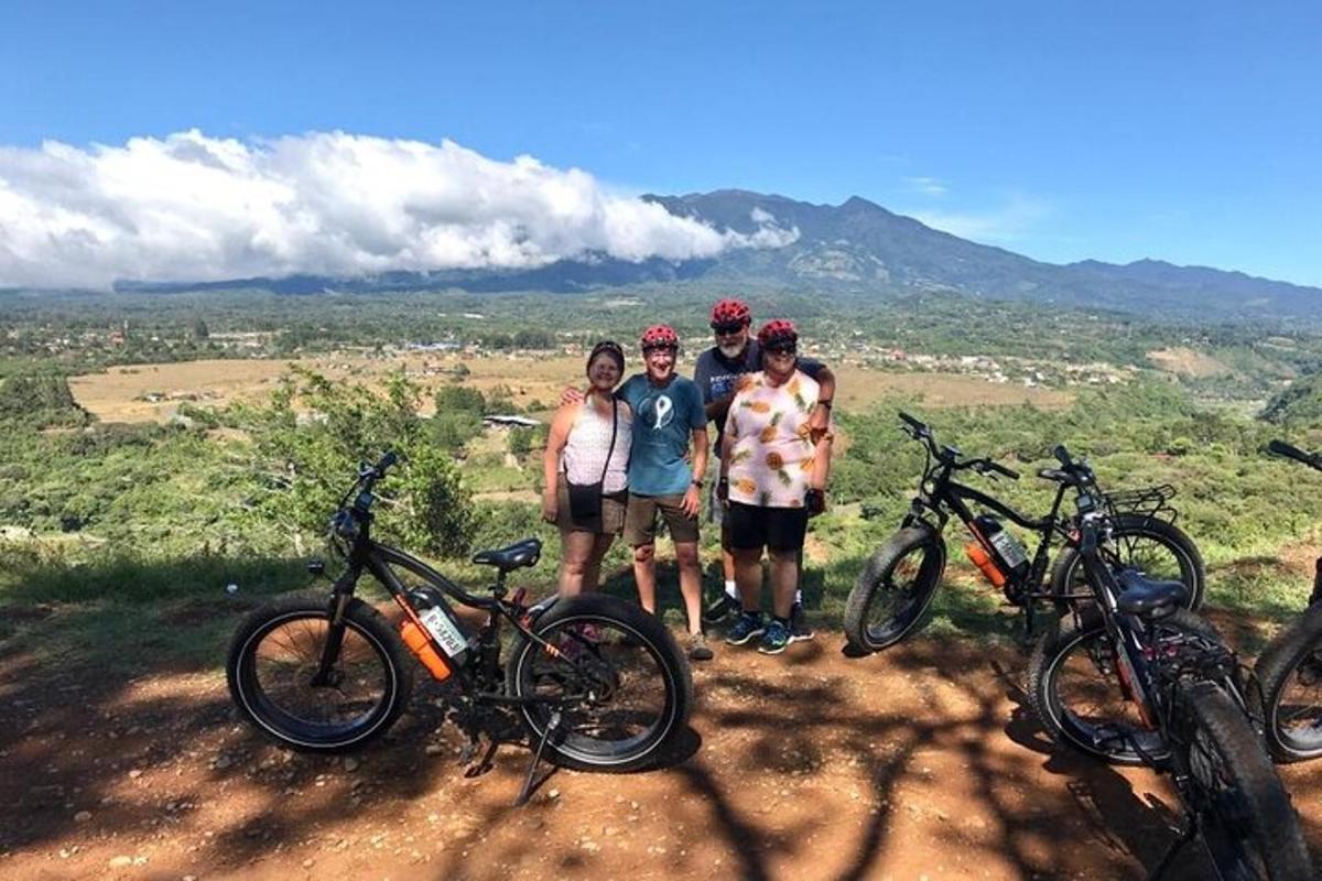 a group of people standing on a hill with bikes