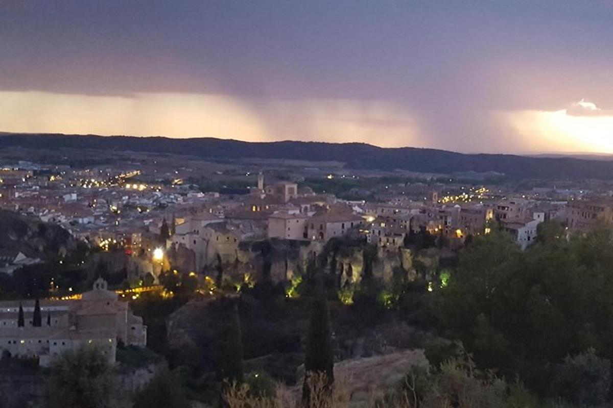 a city at night with a rainbow in the sky