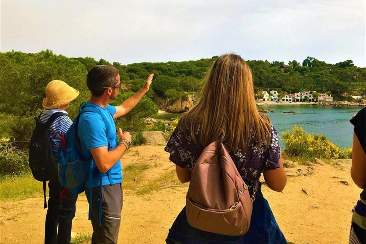 un gruppo di persone in piedi su una spiaggia che guarda l'acqua