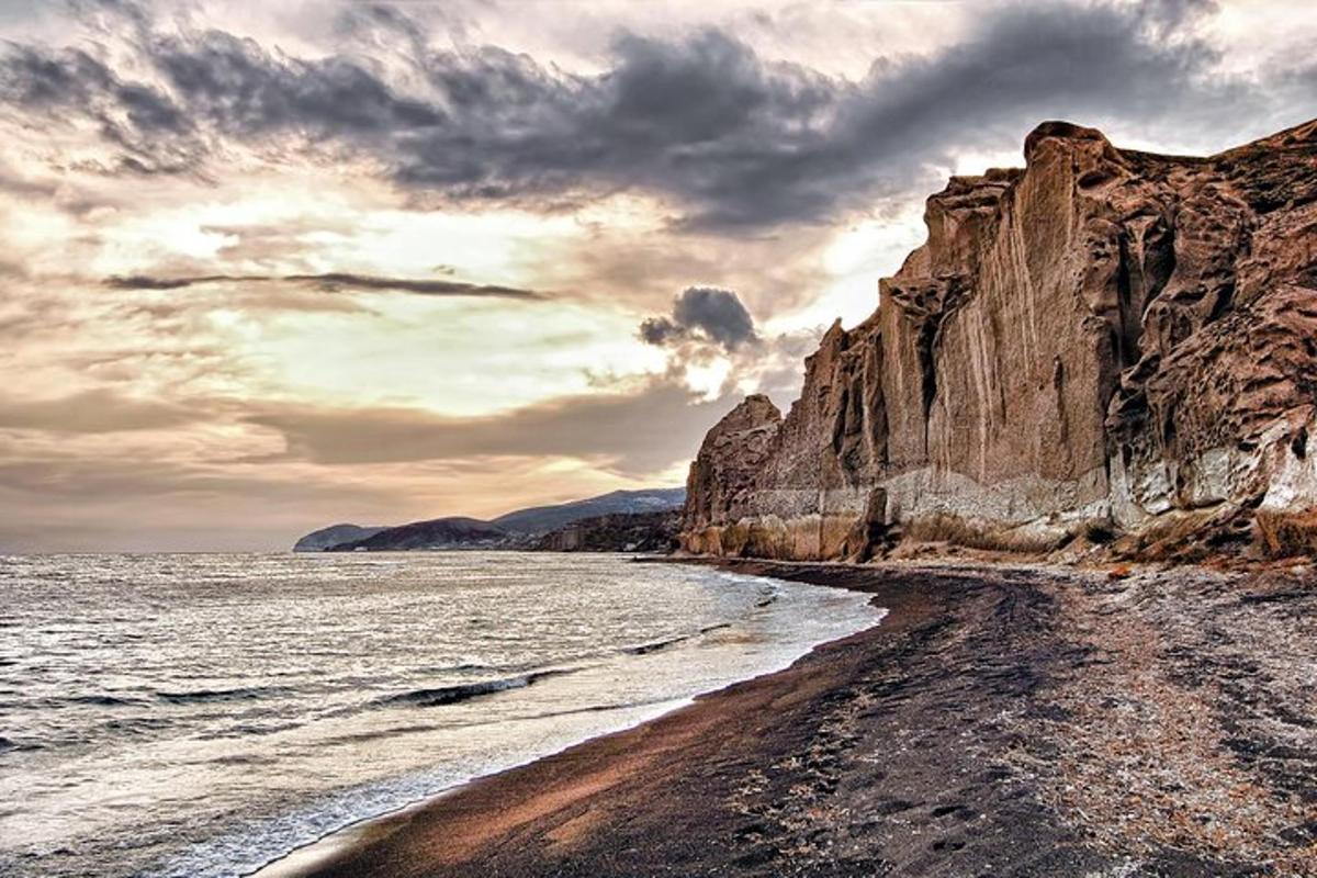 une plage avec un grand mur rocheux à côté de l'océan