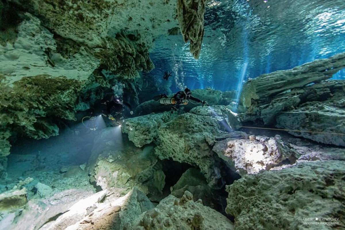 a diver in a cave with rocks and water