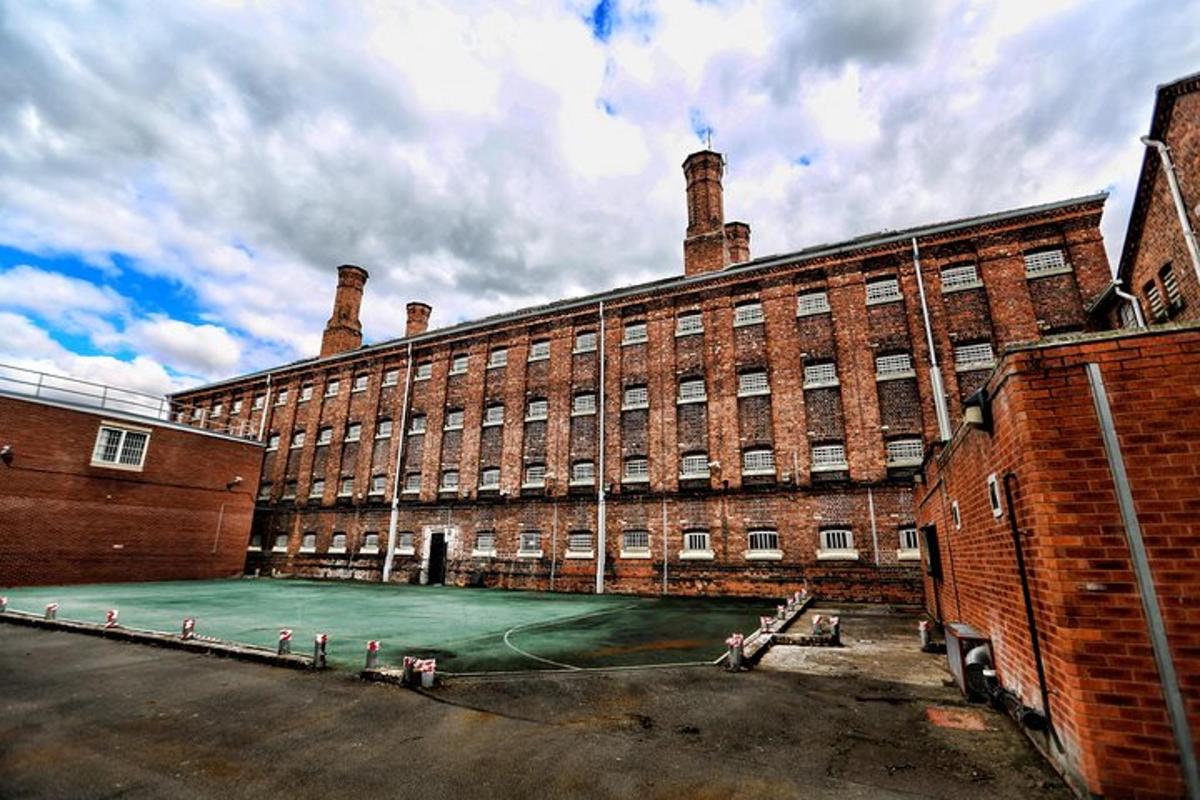 a large brick building with a tennis court in front of it