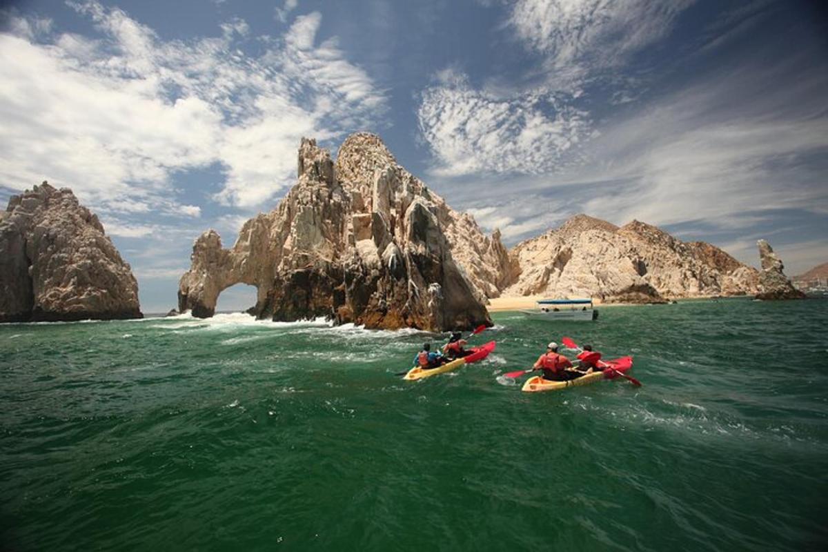 un gruppo di persone in kayak in acqua vicino a una formazione rocciosa