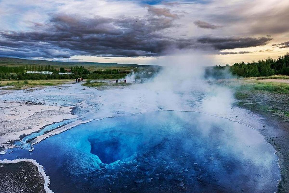 een afbeelding van een geiser met blauw water en stoom