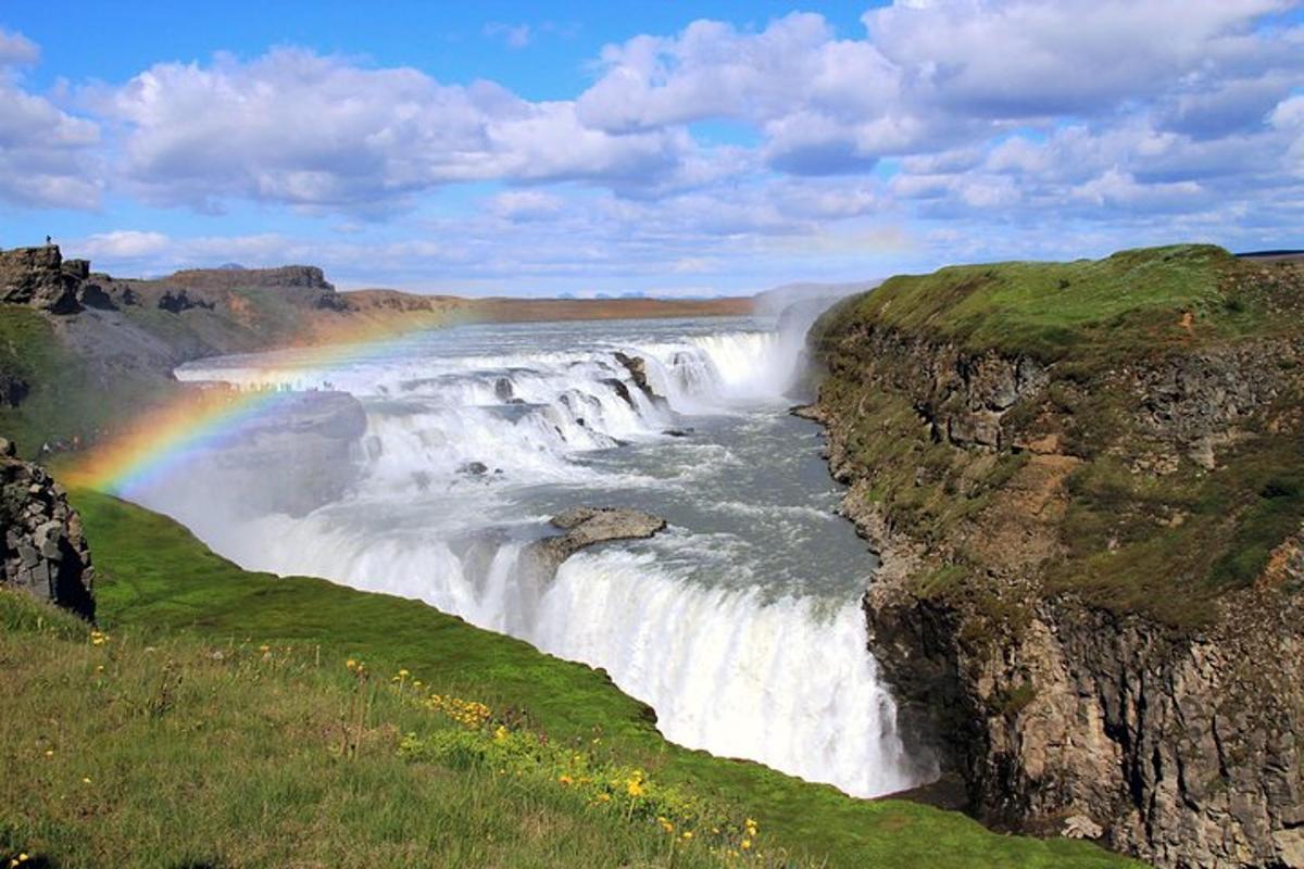 um arco-íris sobre uma cachoeira com um rio