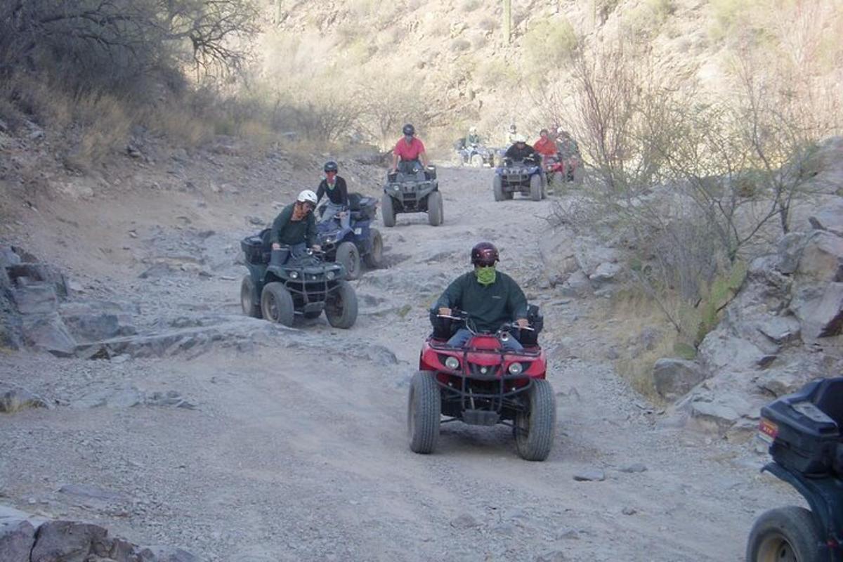 a group of people riding atvs on a dirt road