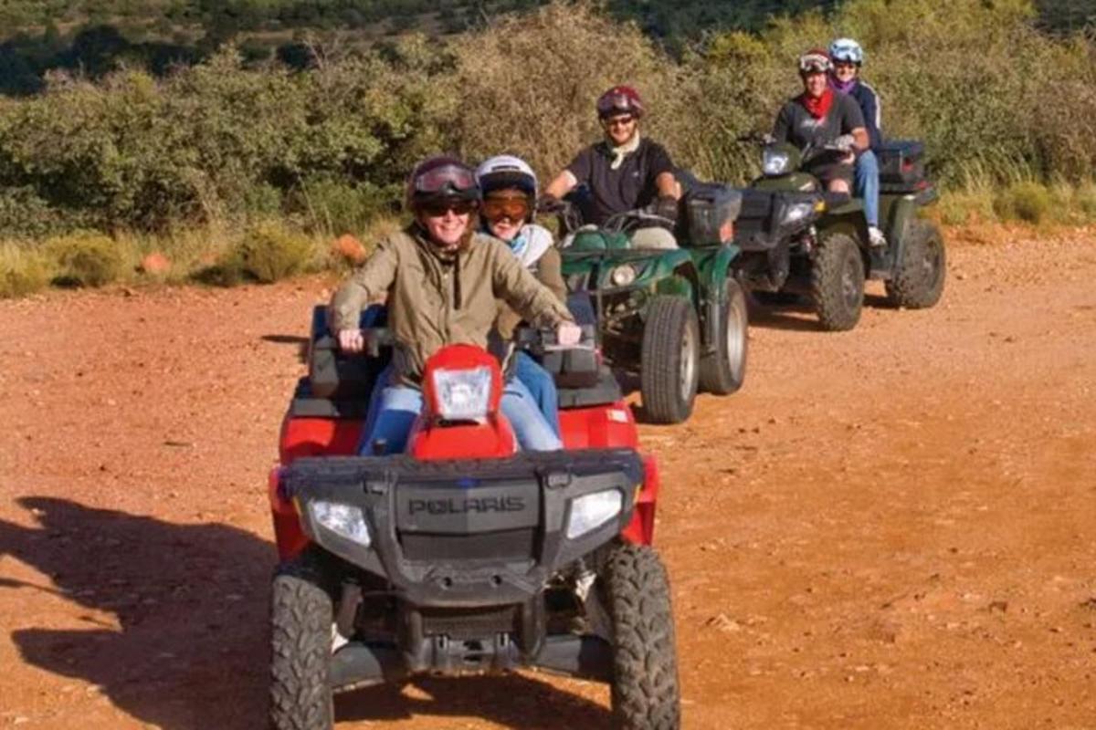 a group of people riding atvs on a dirt road