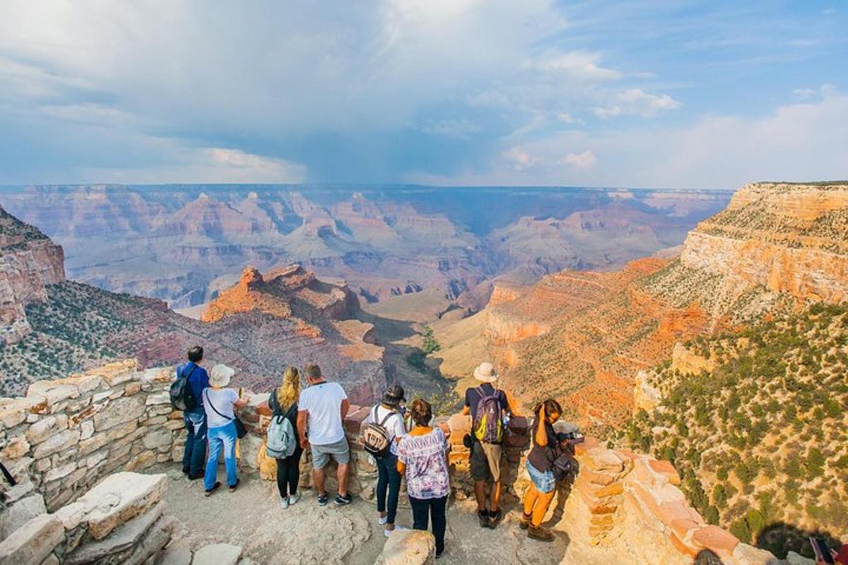un gruppo di persone in piedi sul bordo del Grand Canyon