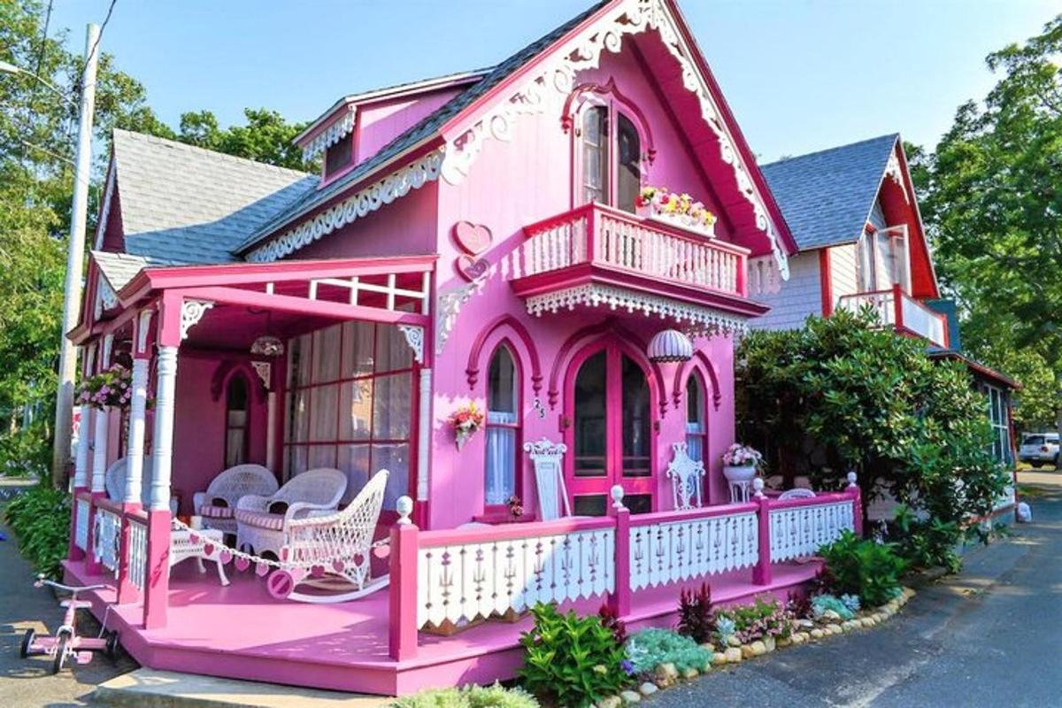 a pink house with a porch and chairs in it