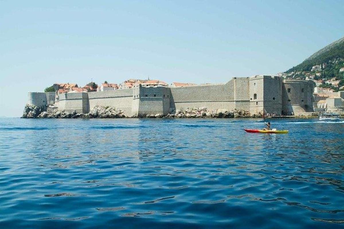 eine Person in einem Kajak im Wasser vor einem Schloss