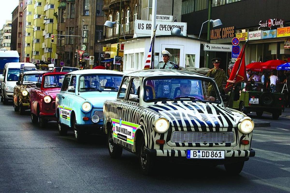 a group of old cars driving down a city street