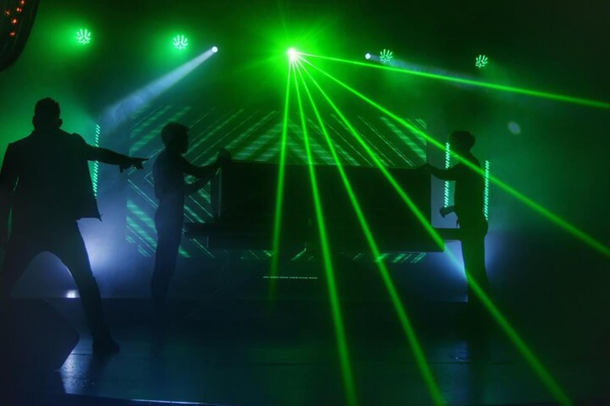un gruppo di persone che ballano su un palco con luci verdi