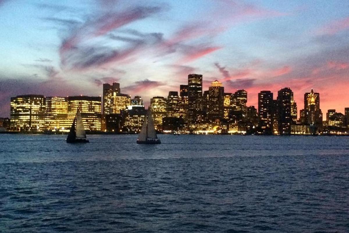 two sailboats in the water in front of a city