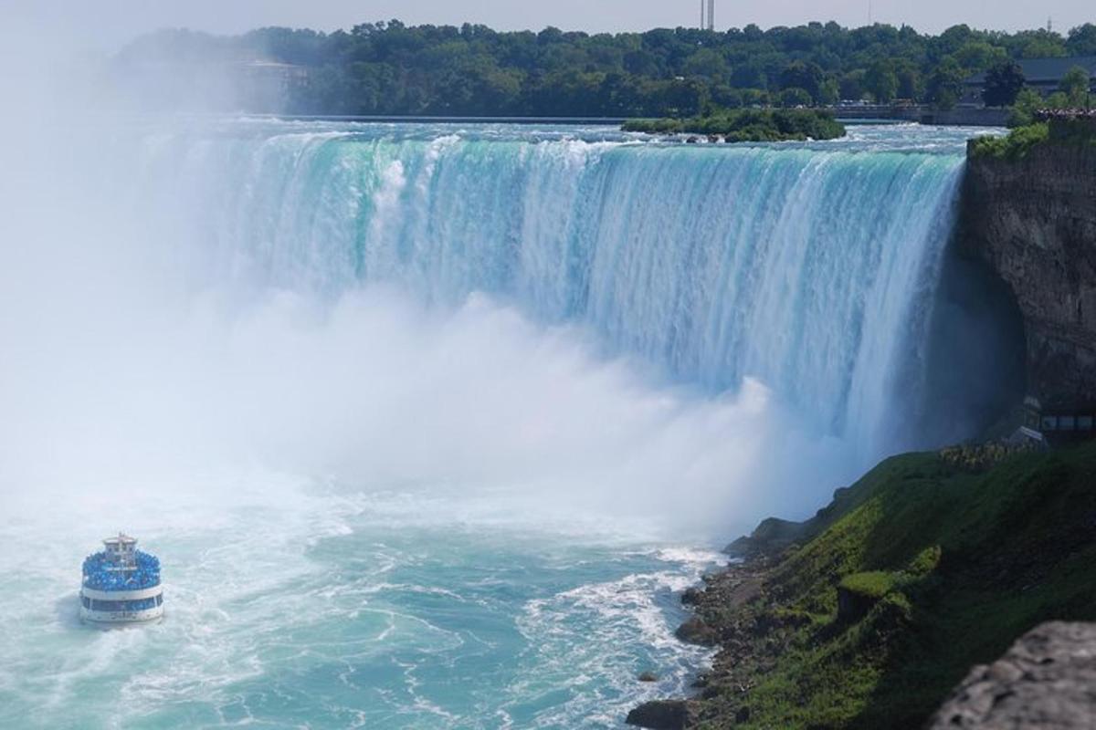 a blue boat in front of a waterfall