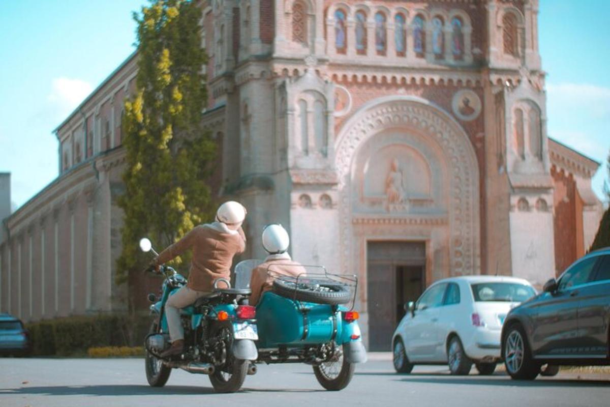 two people riding a motorcycle in front of a building