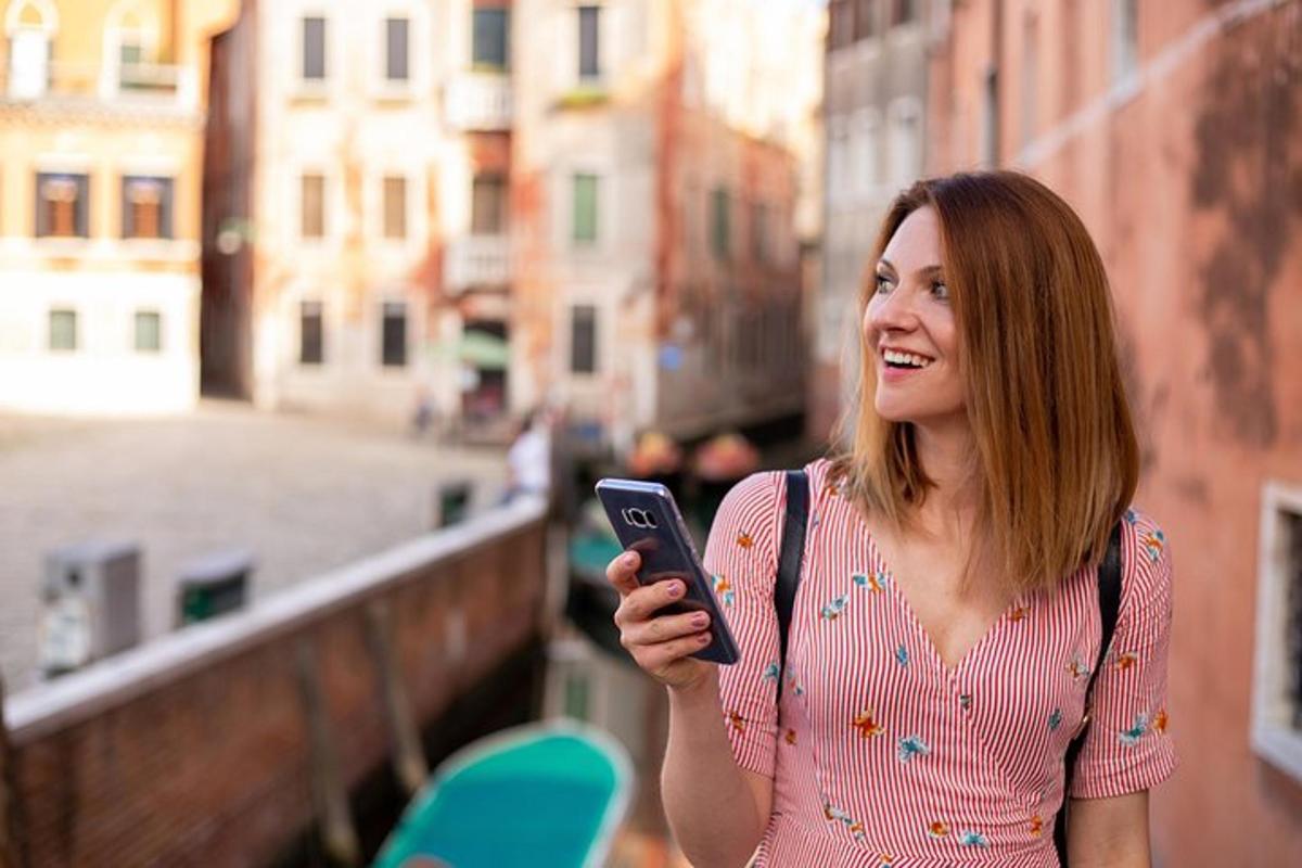 una dona somriu mentre mira el seu telèfon mòbil