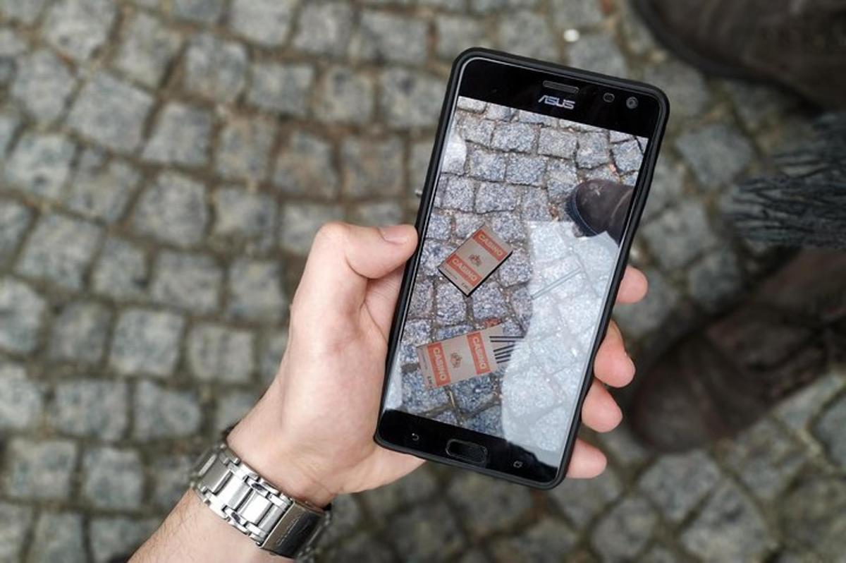 osoba trzymająca telefon komórkowy z mapą na nim