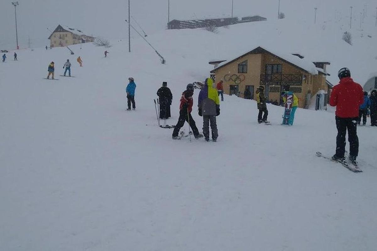 un grup de oameni care stăteau în zăpadă la o cabană de schi