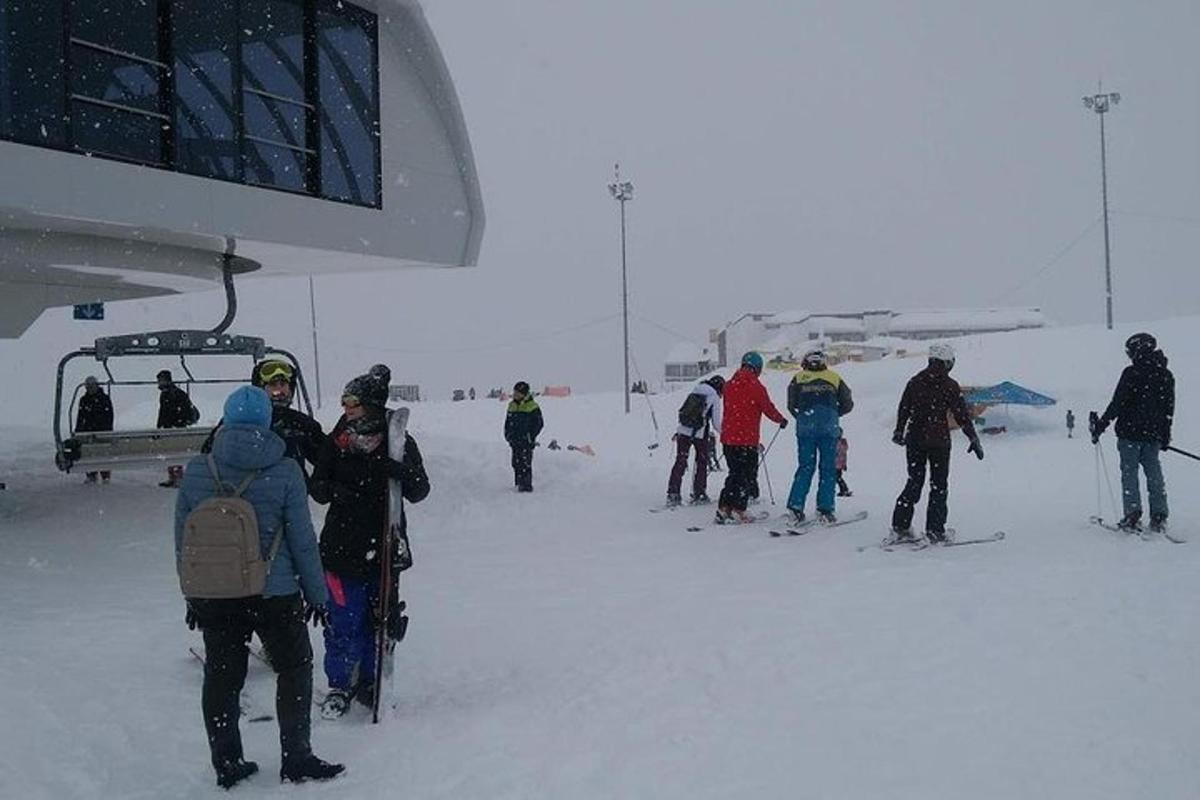 skupina ljudi, ki stojijo v snegu ob žičnici