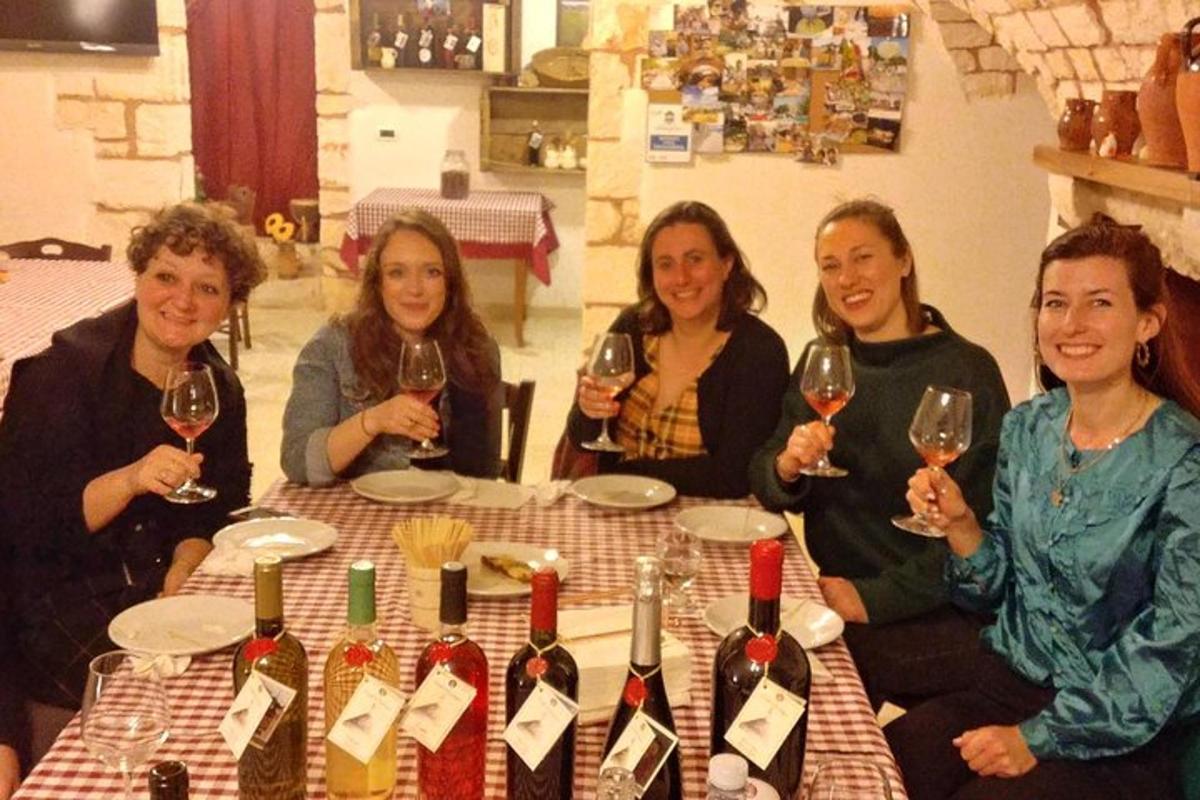 a group of women sitting around a table with wine glasses