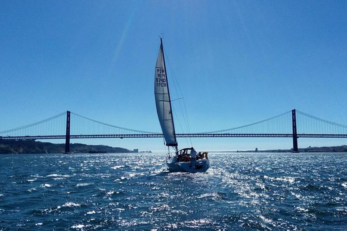 una barca a vela in acqua con un ponte sullo sfondo