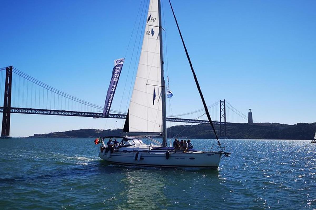 una barca a vela in acqua con un ponte sullo sfondo