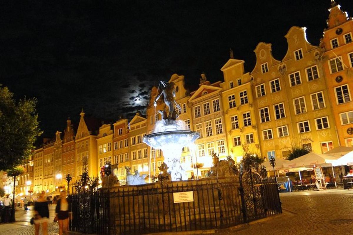 un grande edificio con una fontana di fronte di notte