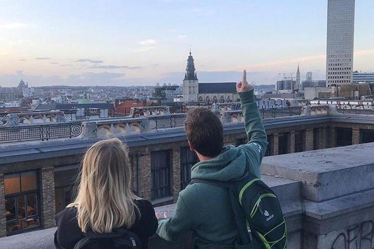 dva lidé sedící na římse a dívající se na město