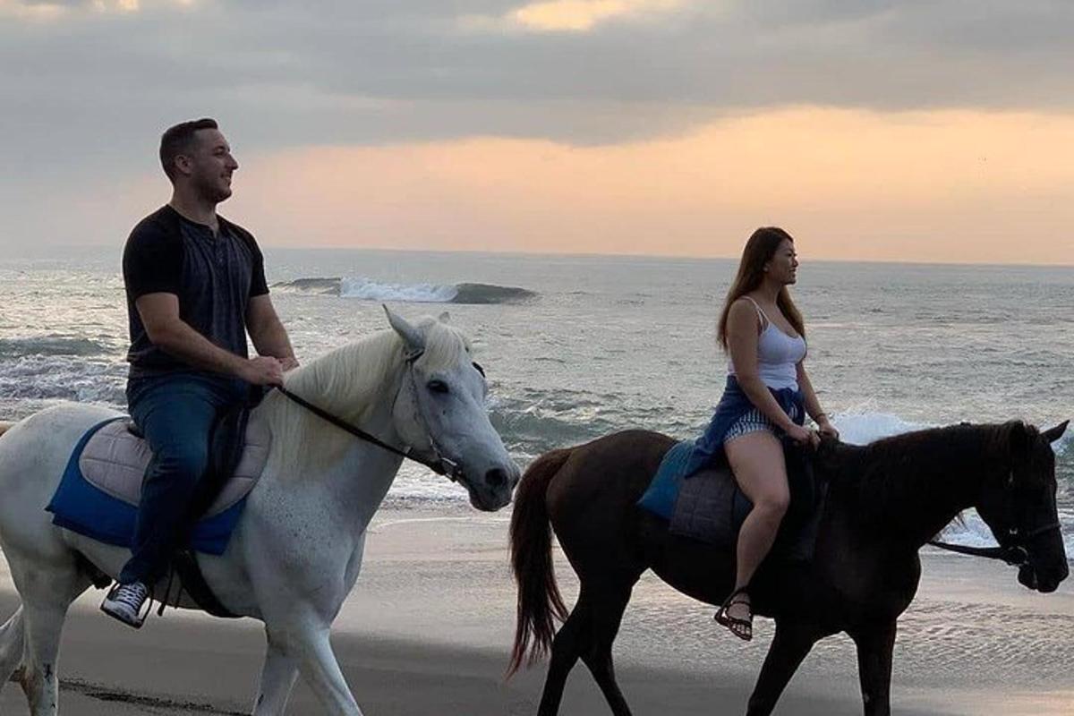 一男一女在海滩上骑马