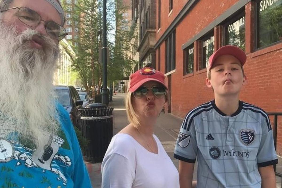 en kvinne og en mann som står ved siden av en gutt