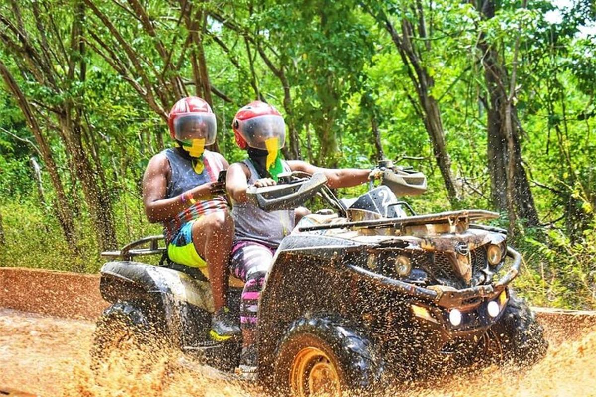 due persone che viaggiano su un quad nel fango