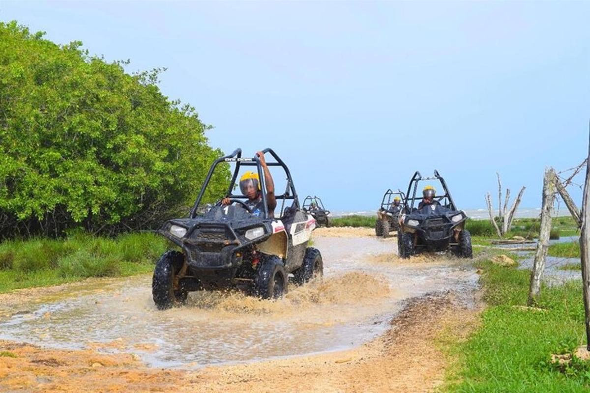 due persone in sella a quad su una strada sterrata fangosa