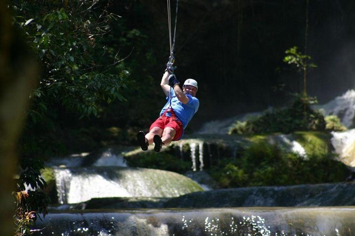 un uomo appeso a una corda sopra una cascata