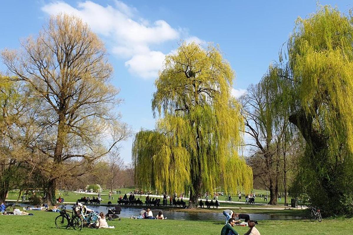 um parque com pessoas sentadas na grama perto de um lago