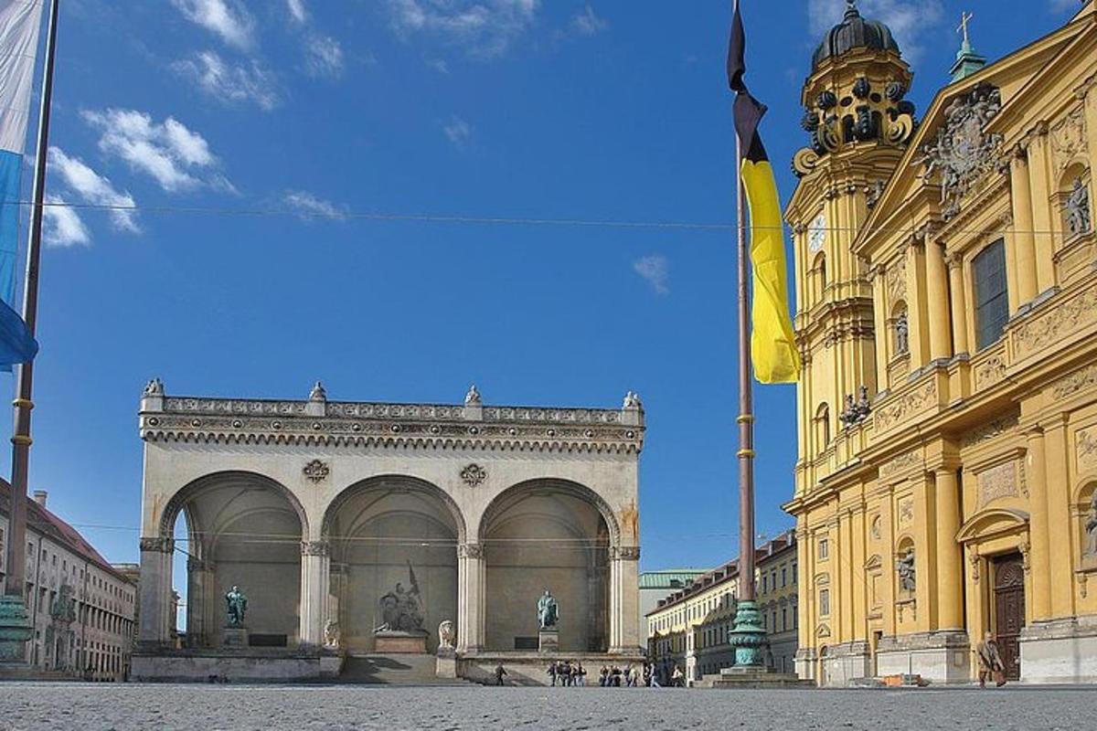um grande edifício amarelo com uma torre de relógio em uma rua