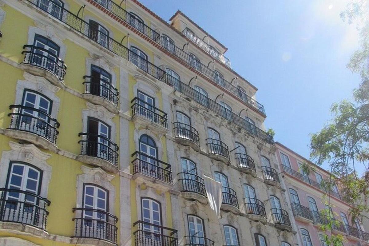 Un gran edificio amarillo con balcones y ventanas.