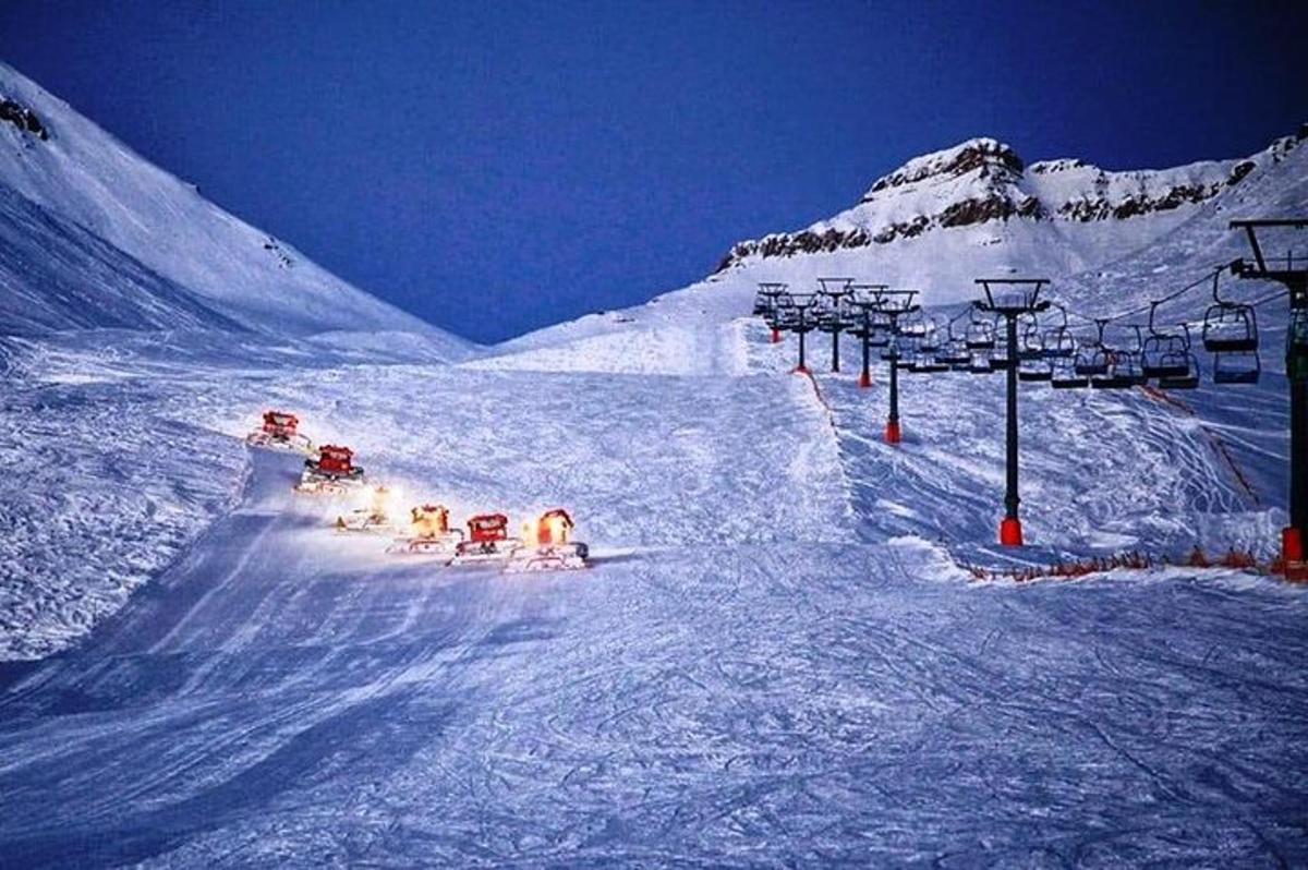 un gruppo di persone che sciano giù da una montagna innevata