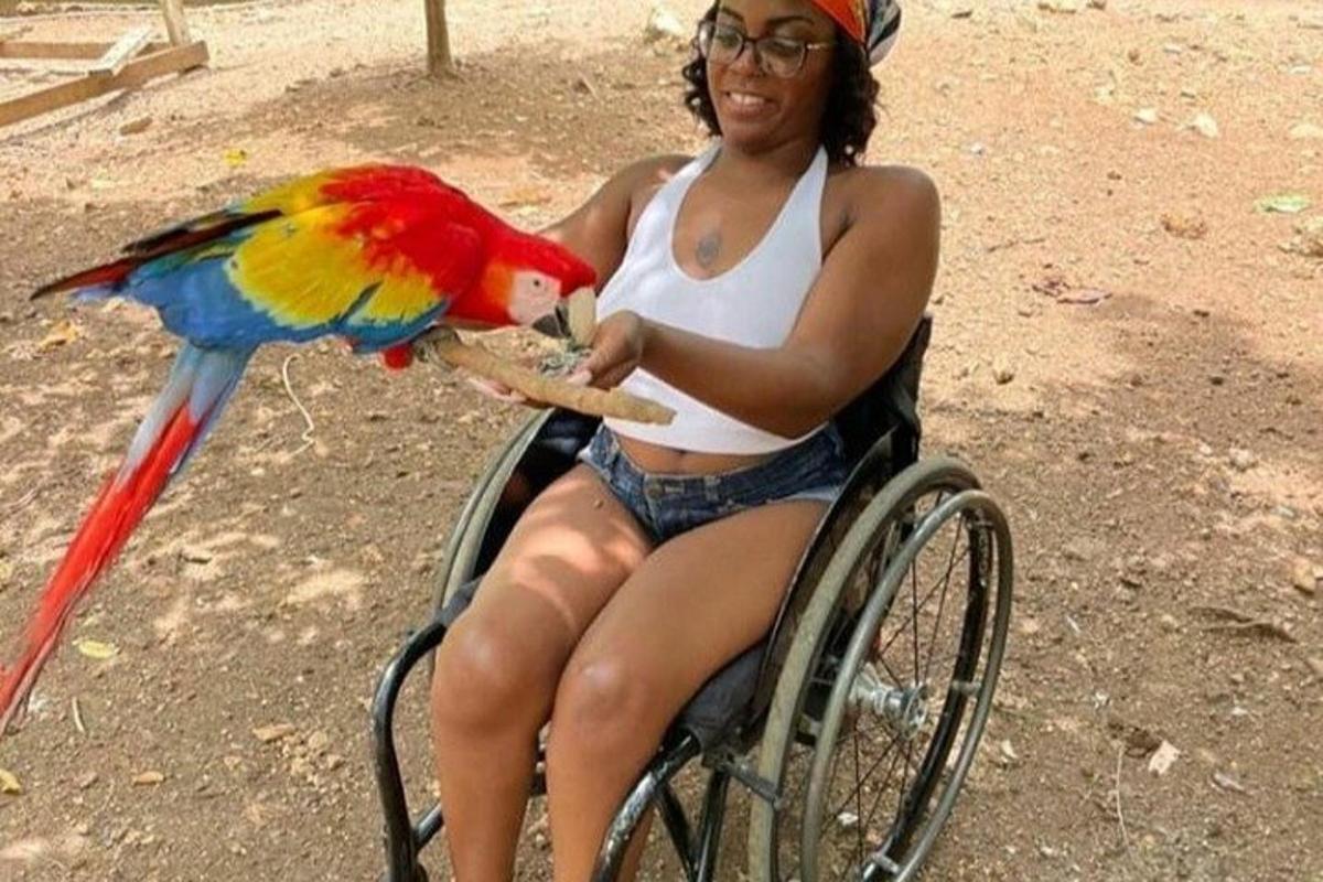 a woman sitting in a wheelchair with a parrot