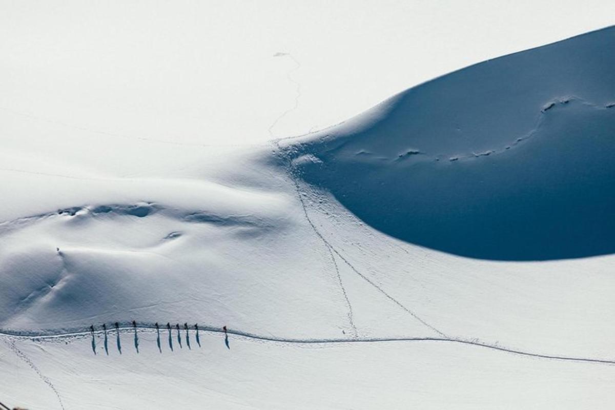um grupo de pessoas esquiando montanha abaixo coberta de neve