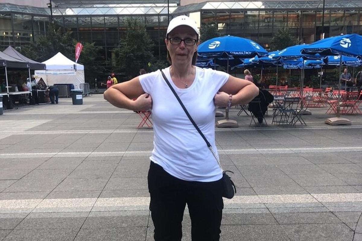a woman standing on a street with her arms crossed