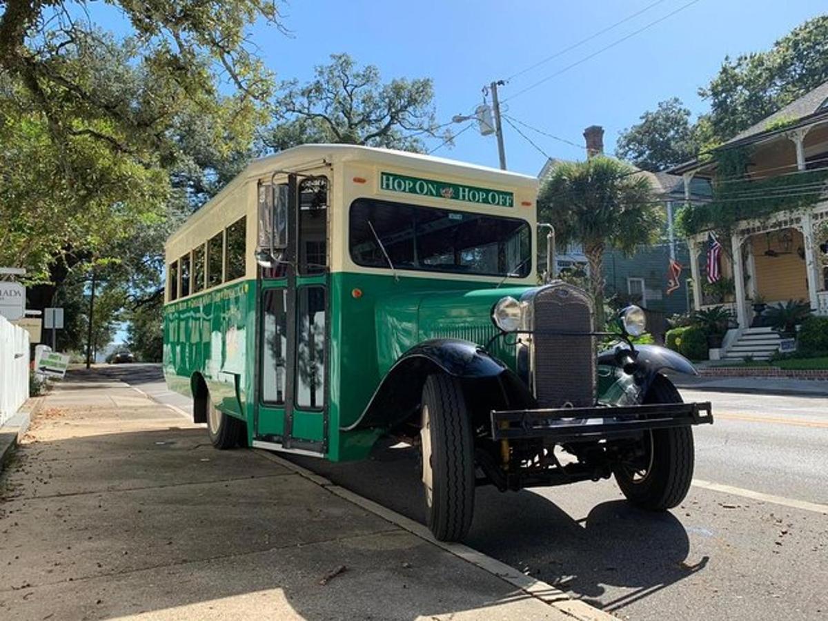 a green and white bus parked on the side of a street