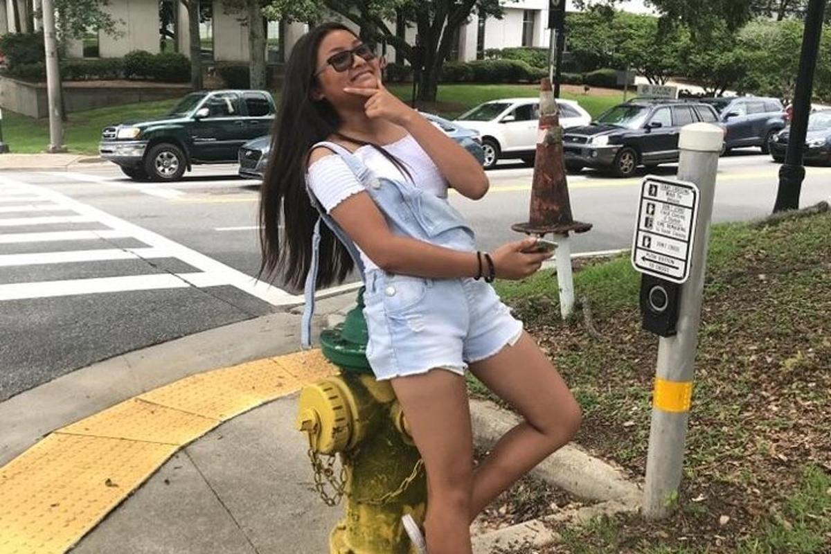 Una mujer está sentada en una boca de incendios
