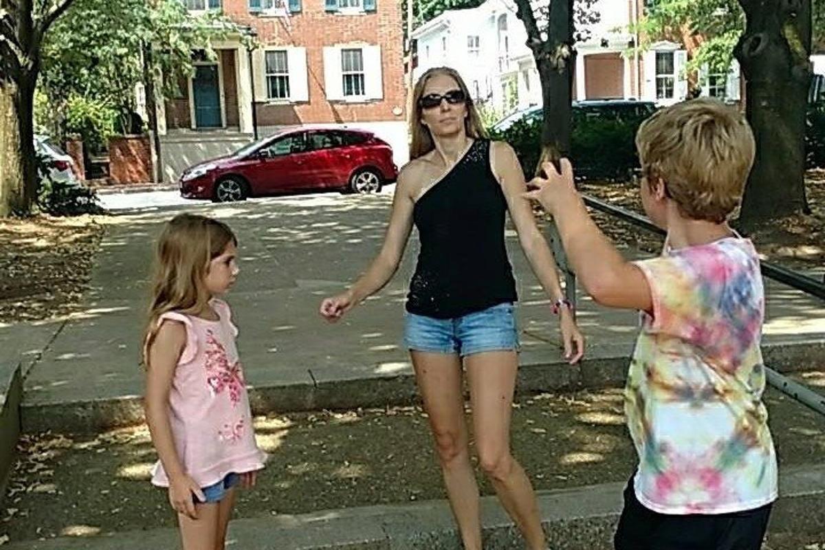 una donna e due bambini che giocano con un frisbee