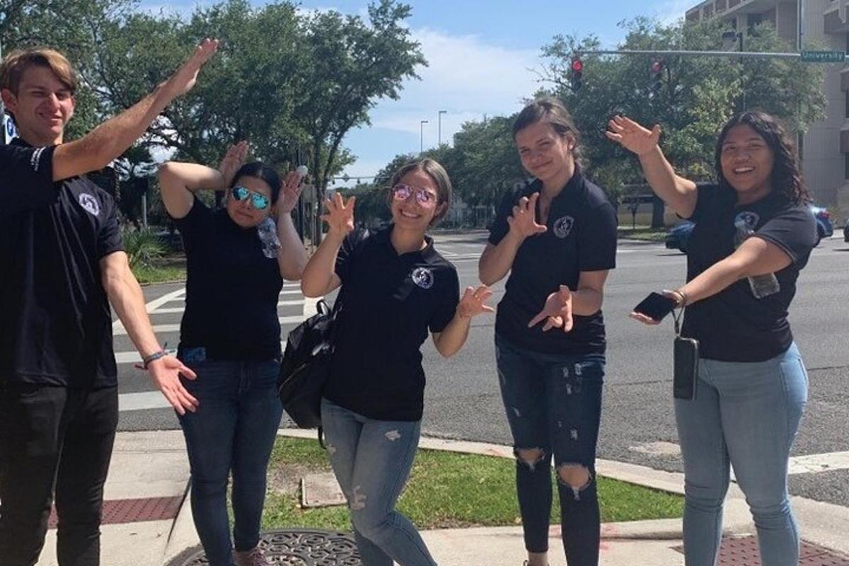 a group of people in black shirts standing on a street