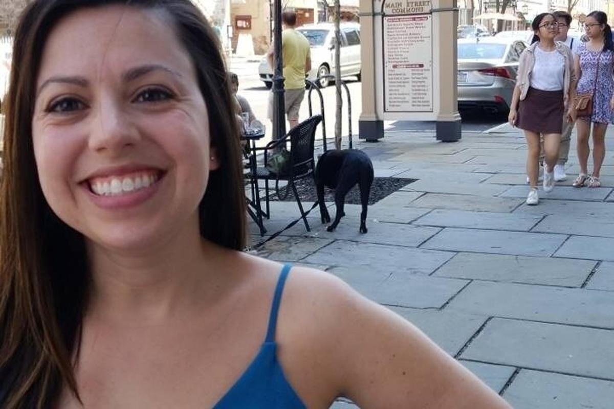 una dona dreta a la vorera amb un gos